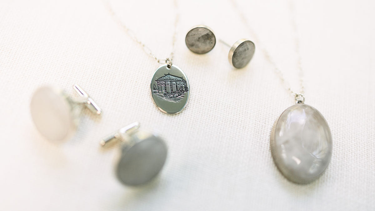 Matching set of quartz jewelry with a sterling silver charm on a white background