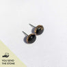 Gold stud earring set with a black granite stone and engraved on the edge. Text on the image reads, "You send the stone."